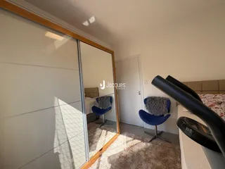 Quarto com porta de vidro refletindo outro ambiente interno.