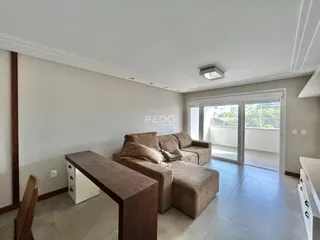Sala de estar com sofá e porta de vidro.