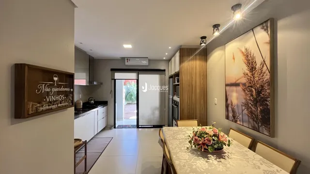 Sala de jantar e cozinha integrada com piso claro.