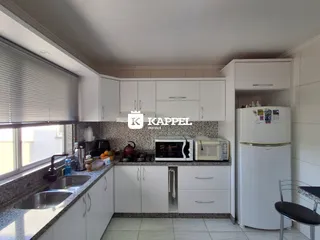 Cozinha moderna com armários brancos e bancadas de granito.