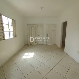 Hall de entrada com piso de cerâmica claro e paredes brancas.