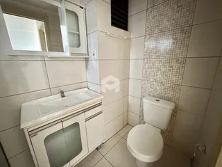 Foto de um banheiro com revestimento de azulejos brancos.