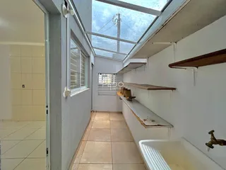 Corredor com piso de cerâmica e claraboia em uma residência.