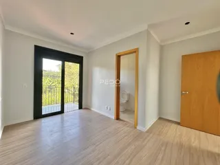 Sala de estar com porta de vidro abrindo para a varanda.