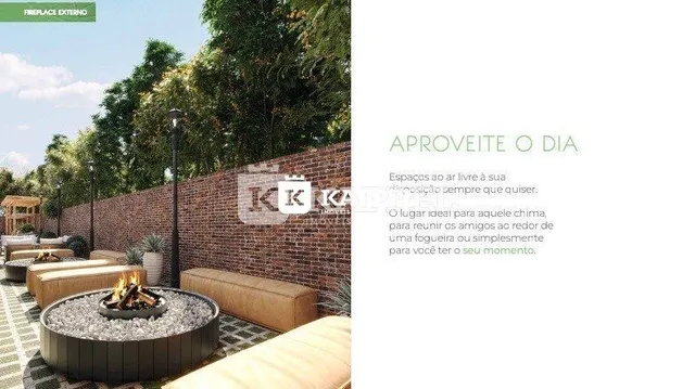 Vista externa de um jardim com vegetação e parede de tijolos.