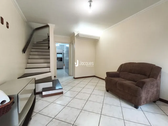 A sala de estar mostra um ambiente com piso de cerâmica e um sofá.