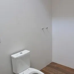 Foto de um vaso sanitário branco em um ambiente.