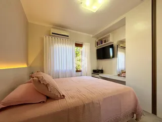 Quarto com cama e janela bem iluminada.