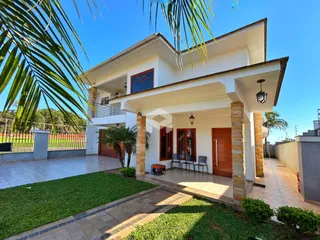 Fachada de uma casa em Lajeado, Brasil, com jardim e área externa pavimentada.