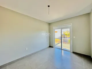 Vista interna de um ambiente com piso de cerâmica e porta de vidro.