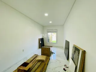 Interior de um ambiente com paredes brancas e piso claro.