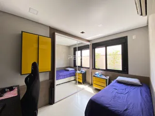 Quarto com porta de vidro que se abre para outro ambiente.