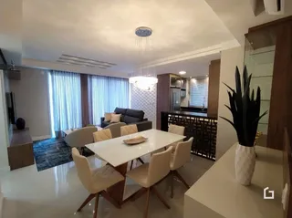 Sala de jantar com mesa e cadeiras em ambiente interno.