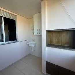 Vista de um corredor interno com paredes brancas e piso claro.