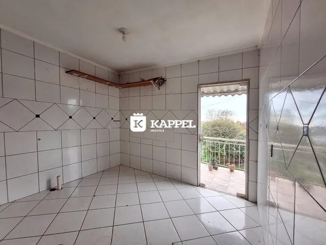 Uma sala com piso de cerâmica e paredes brancas é mostrada na propriedade.