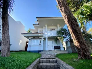 Fachada de uma residência em Lajeado, Brasil, com jardim e árvores.