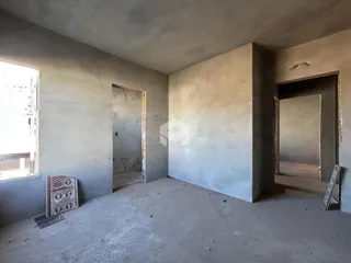 Foto de um cômodo interno em construção com paredes de concreto aparente.