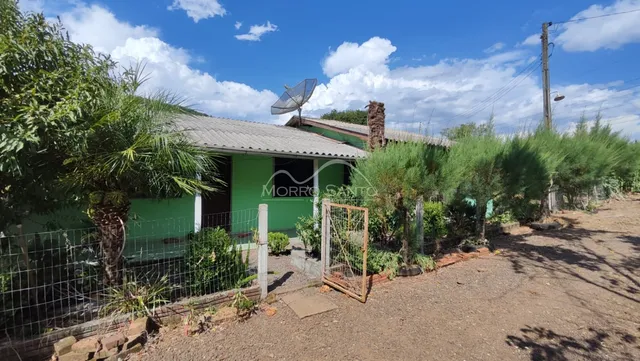 Vista externa de uma casa verde com vegetação no jardim em Lajeado, Brasil.