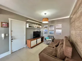 Sala de estar com sofá e televisão em um imóvel no Brasil.