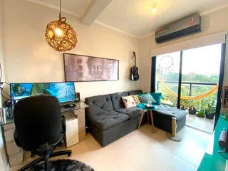 Sala de estar com sofá cinza e vista para a paisagem externa.