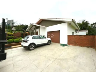 Fachada de uma residência com garagem e muro de tijolos em Lajeado.