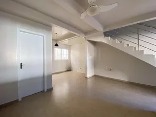 Foto de um hall amplo com escadaria e portas brancas em um imóvel.