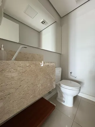 A foto mostra o interior de um banheiro moderno com bancada de mármore.
