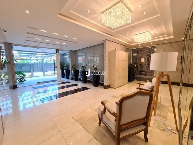 Interior de uma sala de estar com piso de cerâmica e teto decorado.