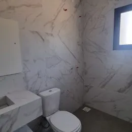 Foto de um banheiro com paredes revestidas em mármore branco.