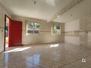Interior de uma sala com piso de cerâmica clara e paredes de azulejo.