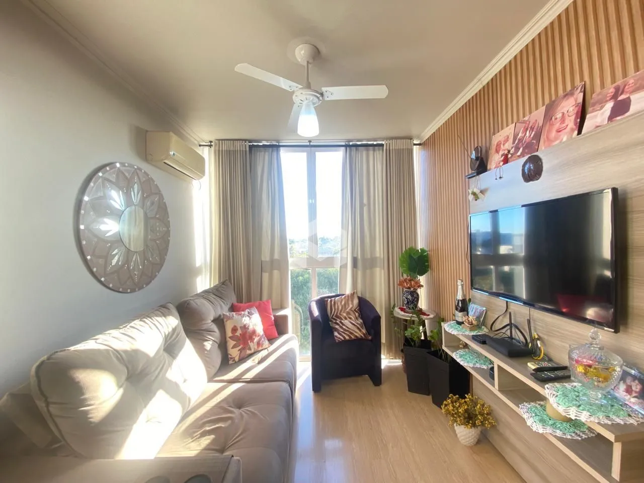 Sala de estar com sofá e televisão em um apartamento.