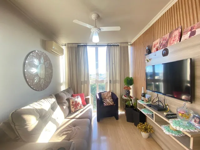 Sala de estar com sofá e televisão em um apartamento.