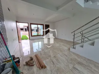 Interior de uma sala de estar com piso de porcelanato claro e acesso a uma porta externa.
