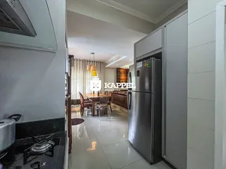 Foto de um ambiente interno mostrando uma sala de jantar e área de cozinha.