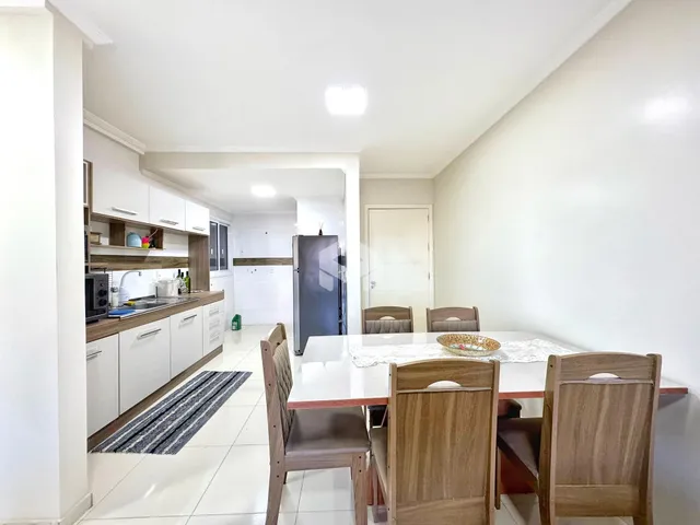 A foto exibe uma área de cozinha e sala de jantar em um imóvel.