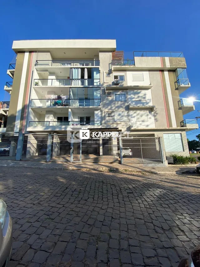 Fachada de um prédio residencial em Lajeado, Brasil, com varandas e muro frontal.