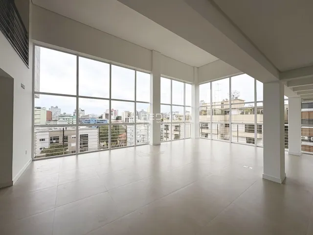 Sala ampla com grandes janelas oferecendo vista da cidade.