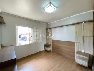 Sala de estar com piso de madeira e janela iluminada.