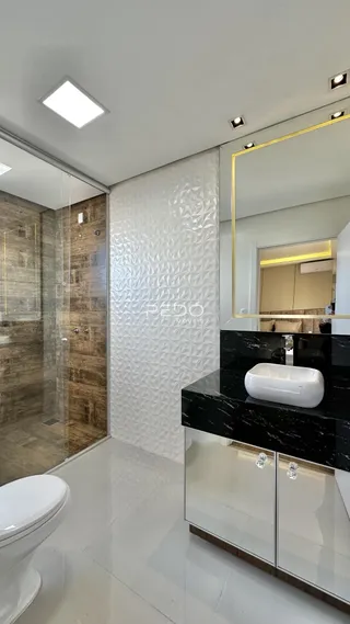 Banheiro moderno com box de vidro e piso branco.
