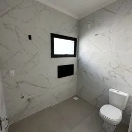 Hall de corredor com paredes de mármore branco.