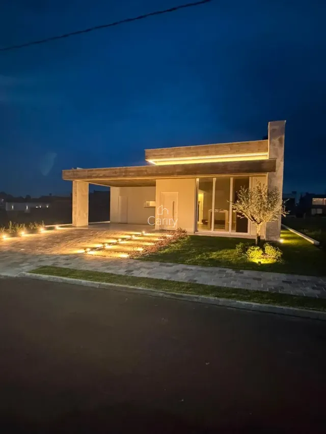 Fachada moderna de uma residência com iluminação noturna.