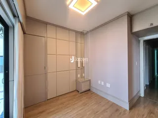 Quarto com armários embutidos e piso de madeira clara.