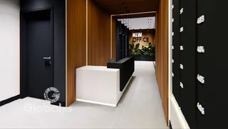 Hallway moderna com portas escuras e painéis de madeira na entrada de um imóvel.
