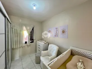 Quarto com janela e decoração de parede clara em um imóvel no Brasil.