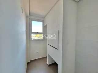 Corredor interno de uma propriedade com paredes brancas e piso claro.