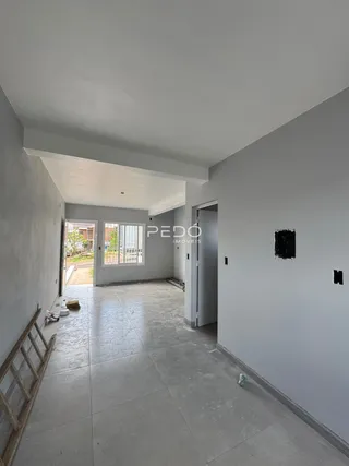 Hall de entrada com piso de cerâmica claro e paredes brancas.