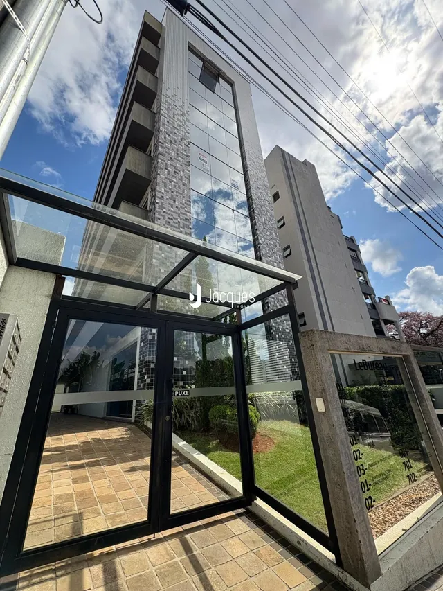 Fachada moderna de um edifício residencial em Lajeado, Brasil com grandes portas de vidro.