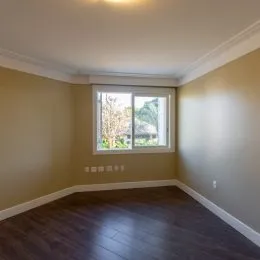 Foto de um cômodo interno com paredes claras e piso de madeira.