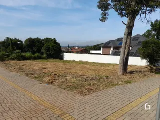 Vista da fachada de uma propriedade com terreno adjacente.