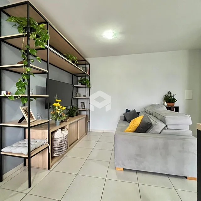 Sala de estar com sofá e estantes em um apartamento.